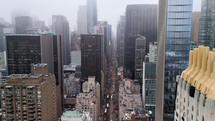 Fototapeta premium Drone view along Midtown Manhattan avenue with skyscrapers and winter haze