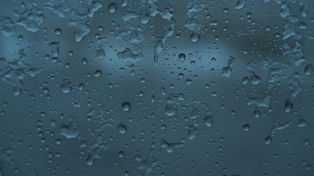 車の窓に落ちるみぞれ交じりの雨