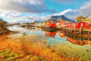 Svolvær waterfront cabins reflected on calm arctic water, Lofoten islands, Norway © Connie