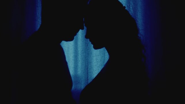 black silhouette two gothic person, loving couple together man face to face sexy beauty young woman in dark room blue moon light. Adult girl happy guy looking at each other eyes with love emotion 4k