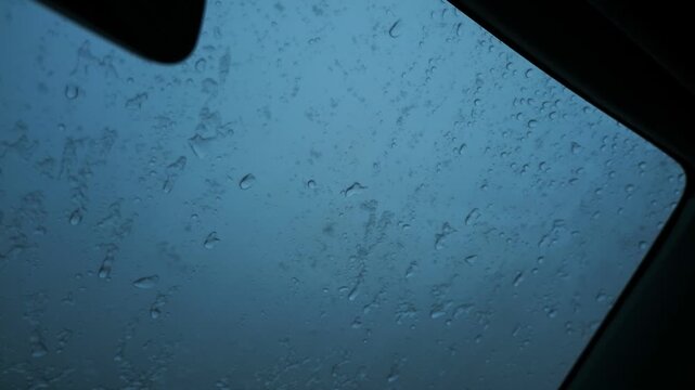 車の窓に落ちるみぞれ交じりの雨