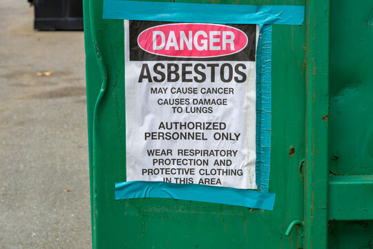 Danger Asbestos Sign on the Side of a Dumpster During a Demolition Project