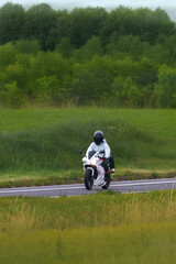 Obraz premium Motorcycle journey along a scenic grass landscape