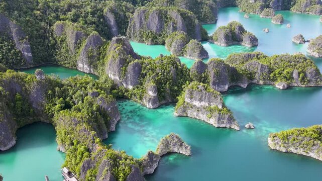 Aerial view of the turquoise Star Lagoon with green rocky hills, Piaynemo, Raja Ampat, Indonesia. 4K