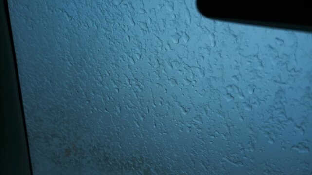 車の窓に落ちるみぞれ交じりの雨