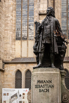 View of the Johann Sebastian Bach statue stands proudly against a backdrop of aged stone architecture in a city square, Leipzig, Saxony, Germany.