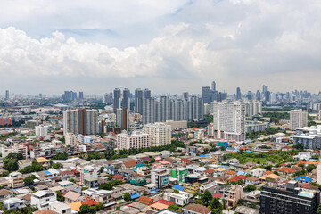 Fototapeta premium Panoramic view of Bangkok city skyline and urban landscape in Ratchada district under a bright blue sky, Thailand.