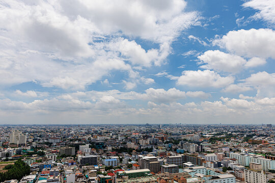 Panoramic view of Bangkok city skyline and urban landscape in Ratchada district under a bright blue sky, Thailand.