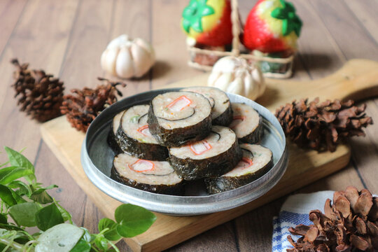 A pile of chicken dim sum wrapped in dried seaweed (nori).