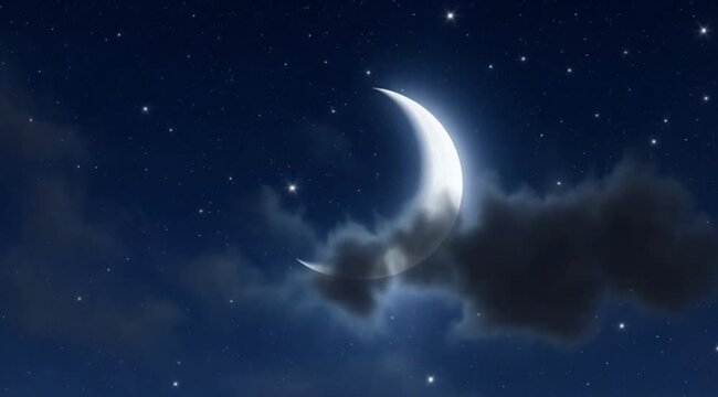 Bright crescent moon shines in a dark blue starry night sky with wispy clouds