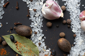 seasonings background with salt, Spices  and garlic served  at black. natural meal additives. healthy food concept. flat lay macro shot