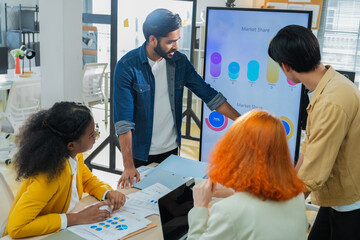 Obraz premium Professionals brainstorming marketing strategy around conference table, analyzing performance charts, teamwork communication, corporate planning meeting, office collaboration.