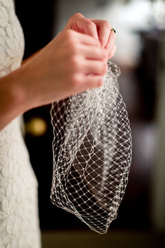hands of the bride holding a lacy veil