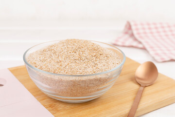 Psyllium husk powder with fresh leaves on wooden table