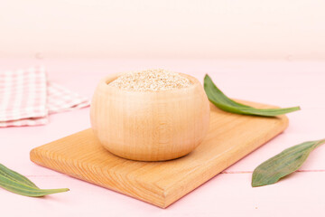 Psyllium husk powder with fresh leaves on wooden table