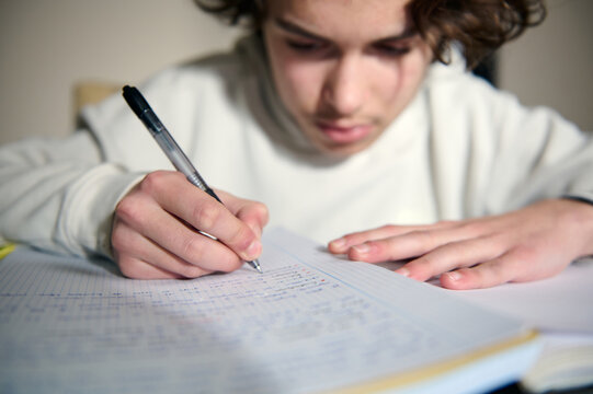 Teenage Boy Doing Homework At A Desk In A Cozy Home Evening Study Session