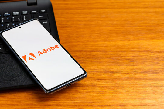 Punta Arenas, Chile &ndash; February 23, 2026: The Adobe Inc. corporate logo,  displayed on a smartphone screen resting on a laptop