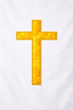 Illuminated yellow patchwork cross on white wall