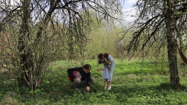 A loving couple in summer clothes walks through a summer park field in nature.v