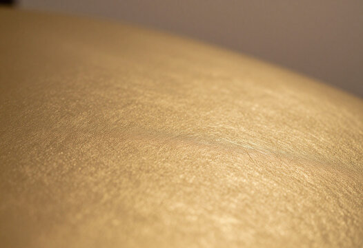 gleaming golden surface subtle texture nuanced shading set blurred backdrop warm diffused