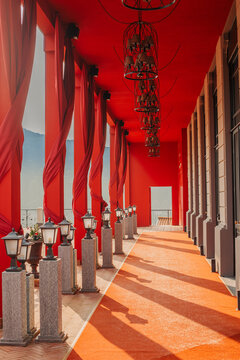 Red fabric covered columns on a building at the village at the top of the bromate funicular in Lake Como, Italy with sunlight coming through