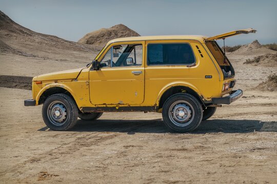 Classic Yellow Lada Niva Off-Road Vehicle in Arid Desert Landscape of Azerbaijan