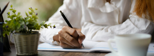 Planner plan Schedule Calendar and reminder agenda, work online at home. Women hand writing daily appointment and note holiday trip in diary at business office desk. Calendar reminder event concept. © prachid