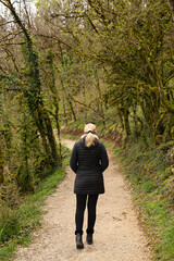 Naklejka premium Mujer paseando por un bosque en invierno.