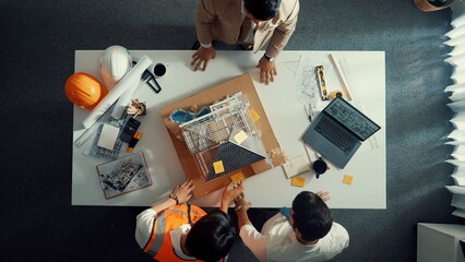 Top aerial view of architect engineer team stick sticky notes on house model while working together...