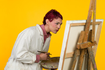 Young artist concentrating while painting artwork