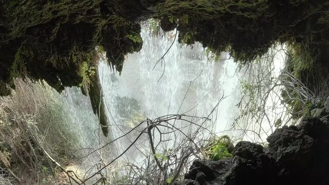 scenic landscape of a waterfall through a cavern entrance