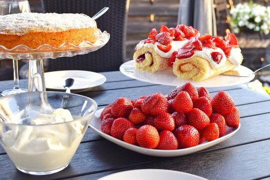 Desserts with strawberries and whipped cream. Swedish fika. Midsummer in Sweden.
