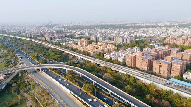 Top down cross traffic highway with cars, trucks aerial. Urban transportation at bridge road at Delhi. Cinematic cityscape of downtown freeway drone shot. Noida Freeway.