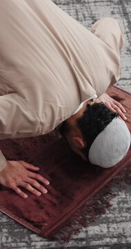 Above, Muslim man and praying in home with faith, praise Allah and spiritual worship in Ramadan. Salah, male person and hope with dua, religious practice and devotion to God with islamic culture