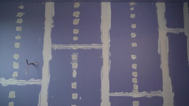 Drywall installing and plastering wall during home renovation