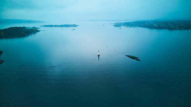 Drone shot of a lighthouse beacon in the foggy Oslofjord, Oslo, Norway.