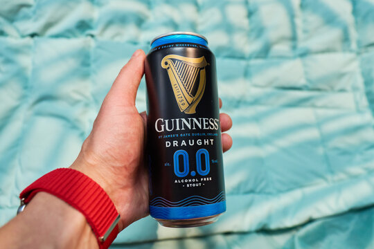 Tyumen, Russia-December 11, 2025: A can guinness of non-alcoholic beer sits on a blue blanket. The can features a dark design and displays information