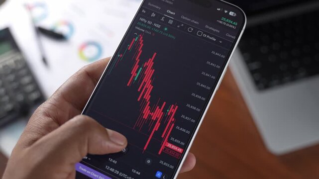 Stock Exchange Broker Analyzing Real-Time Stocks and Exchange Market Charts on Smartphone Using Online Trading App. Investment Agent Working in Office. Close Up.