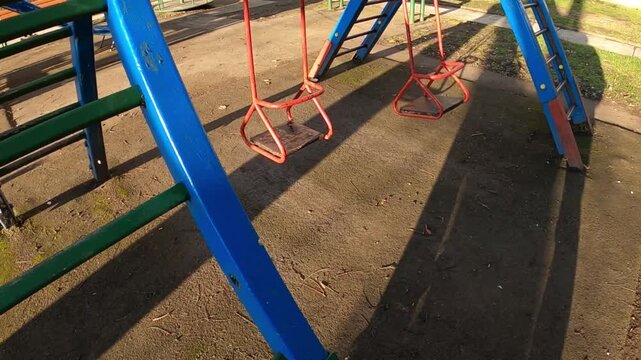 the metal swingset features two wooden seats painted in bright blue and red