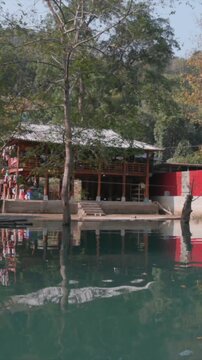 Scenic view of wooden stilt houses reflected in the clear waters of Libo County, China. The traditional architecture blends with the natural landscape. Hang Than Lim, Yen Minh, Ha Giang, Vietnam.