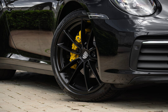 Black Porsche 911 Carrera front wheel detail close up, Luxury sports car external shot