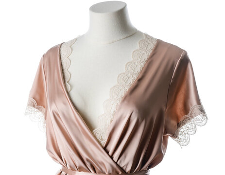 A blush silk robe with lace trim on a mannequin against black