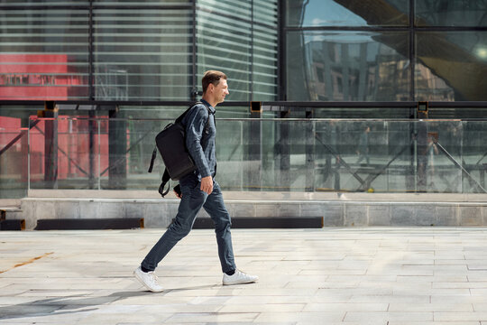 Businessman walking outside a modern city office building