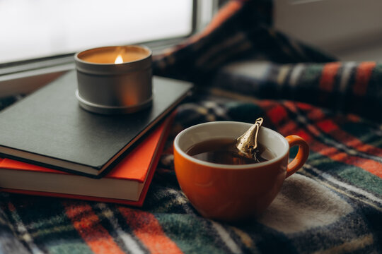 Cozy autumn tea scene with books and candle