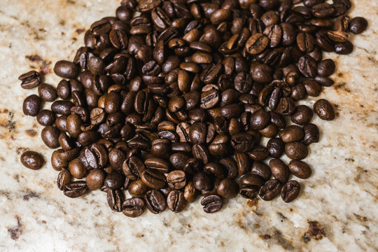 Coffee beans scattered on marble surface