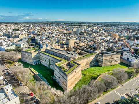 Aerial view of Copertino castle, massive Renaissance fortress features a striking quadrangular plan anchored by four spearhead-shaped bastions and a deep dry moat