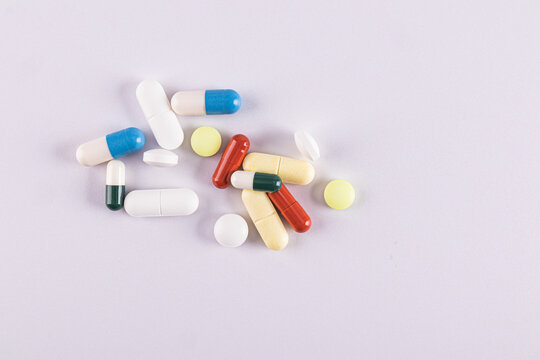 Various colorful pills on a plain background