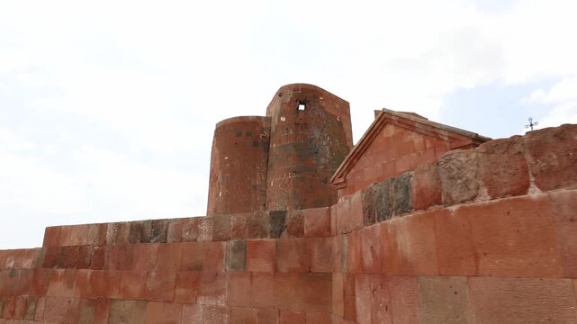 Discover the majestic ruins of Dashtadem Fortress in Armenia. The video showcases the medieval architecture, prominent red tuff stone walls, and a beautiful ancient archway against cloudy skies.

