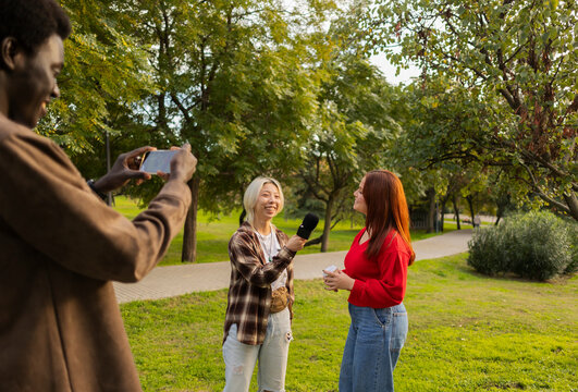 Multiracial friends enjoying a park interview at sunset
