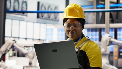 Technician inspecting solar panels production line, analyzing equipment performance, maintaining...